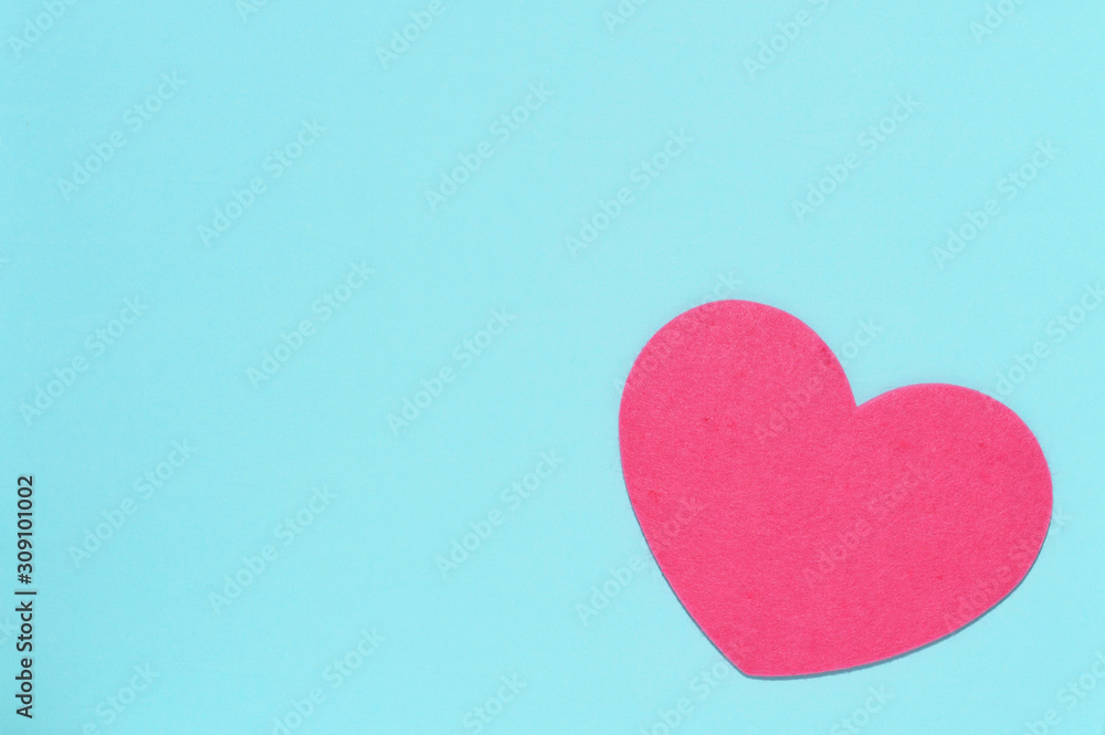 Soft pink heart on a blue background close-up. Greeting card with copy space. Flat lay minimal concept. Valentine's Day background