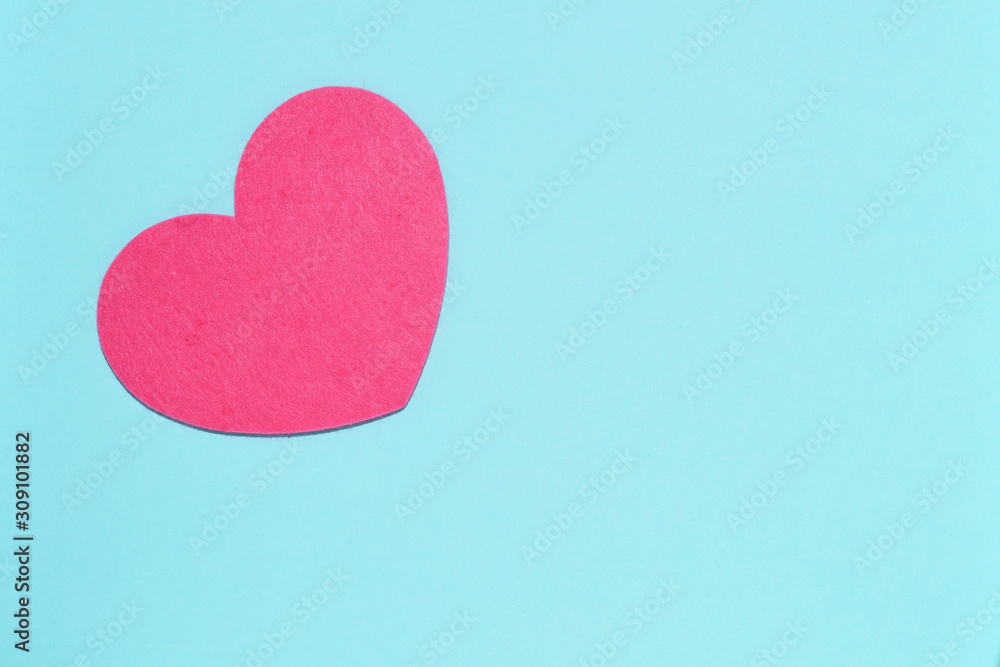 Obraz premium Soft pink heart on a blue background close-up. Greeting card with copy space. Flat lay minimal concept. Valentine's Day background