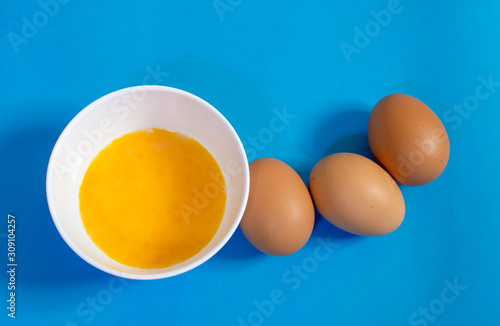  Omelet making set with 6 chicken eggs and yolk cup on a brightly colored floor backgrounds.