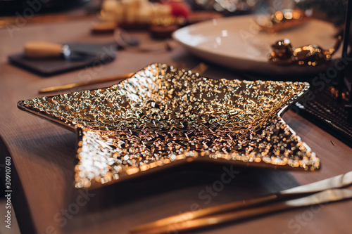 Golden star-shaped plate on New Year table. New Year eve concept