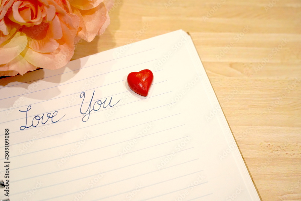 Word Love You on notebook and mini red heart. Sweet image. Valentine's day. Can be use decorate for card, web, advertising. Copy space for any text design.. Word Love You on notebook and mini red heart. Sweet image. Valentine's day. Can be use decorate for card, web, advertising. Copy space for any text design..