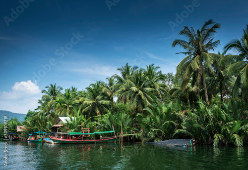 traditional jungle boat at pier on tatai river in cambodia photo
