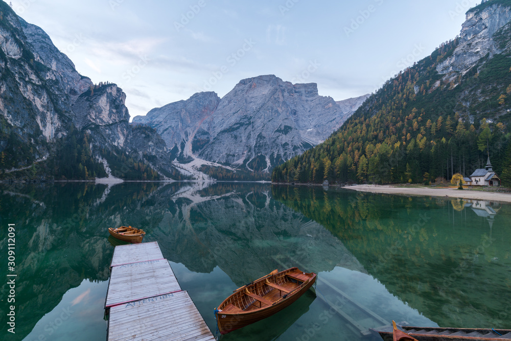 Natural landscapes of the lake Braies (Lago di Braies) with morning fog and reflection of the mountain peak in Dolomites, Italy Natural landscapes of the lake Braies (Lago di Braies) with morning fog and reflection of the mountain peak in Dolomites, Italy