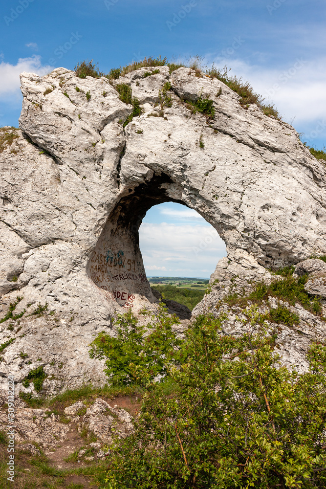 A summer view of a monadnock rock with a hole in it