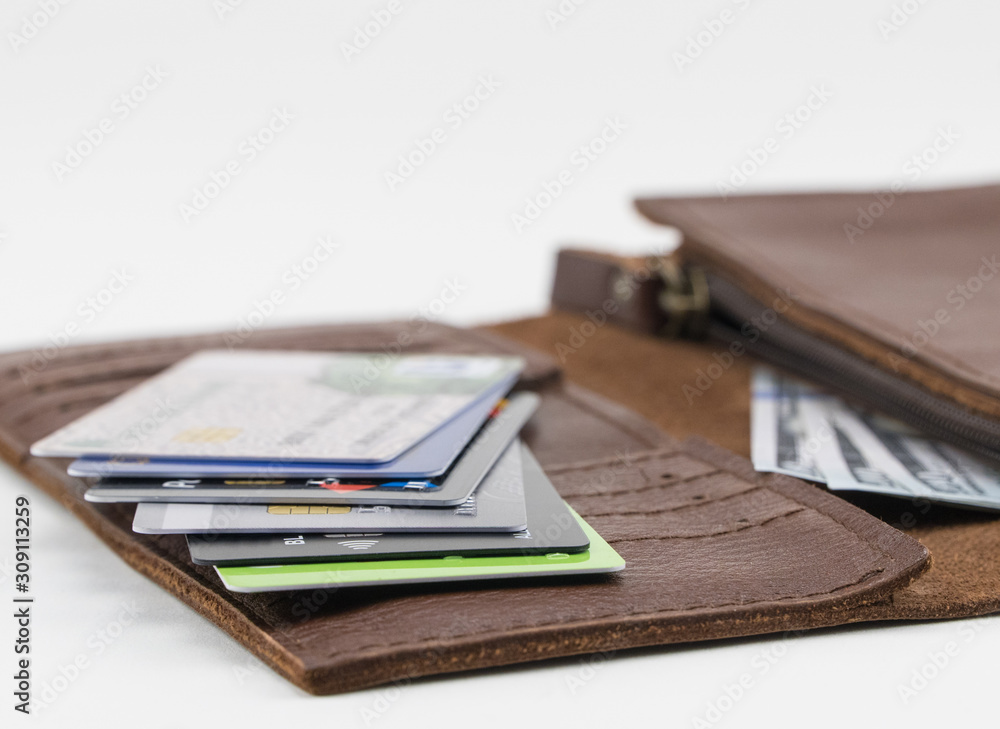 Brown wallet with credit cards and hundred dollar bills on white background Brown wallet with credit cards and hundred dollar bills on white background