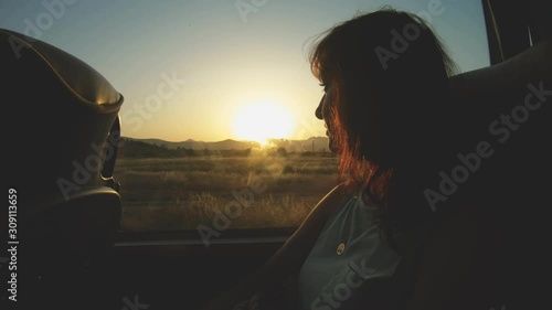 Tourist girl looks through bus window to nature landscape on sunset in move. Sightseeing trip and Travel. Vacation in Montenegro, excursion photo