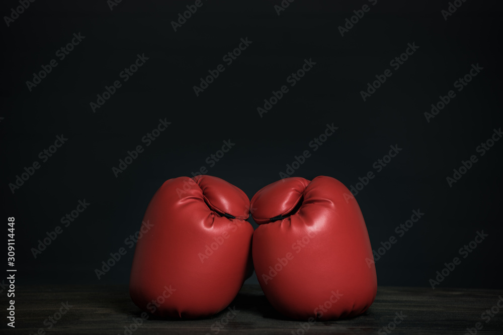 Pair of red boxing gloves on a black background. Copy space