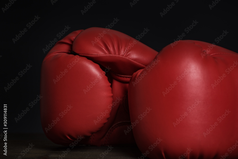 Pair of red boxing gloves on a black background. Close up