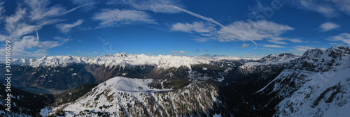 Fototapeta Naklejka Na Ścianę i Meble -  Panoramic aerial view of  Brenta Dolomites, snow on the slopes of the Alps  Madonna di Campiglio, Pinzolo, Italy. The most popular, ski resorts in Italy. Aerial photography with drone. Ski slopes