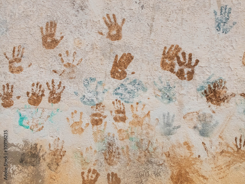 Blue and brown paint palm prints on the textured plaster
