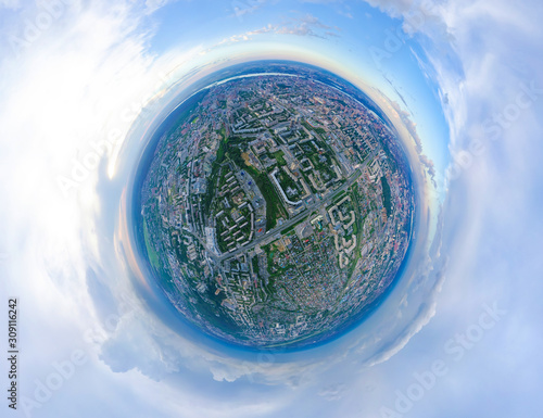 Aerial view of the city with traffic, streets and buildings with green trees and rails under the blue sky with clouds at summer day in Novosibirsk, Ippodromskaya. Panoramic 360 degrees of the panet.