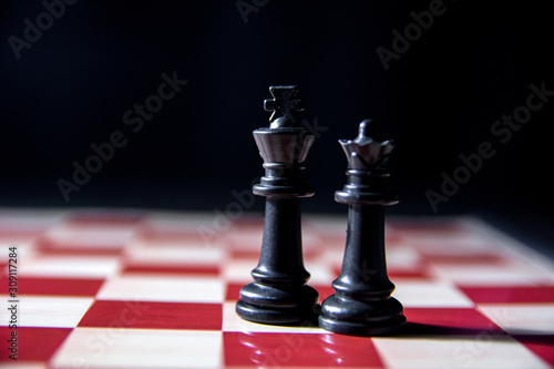 Close up of black king and queen on chess board