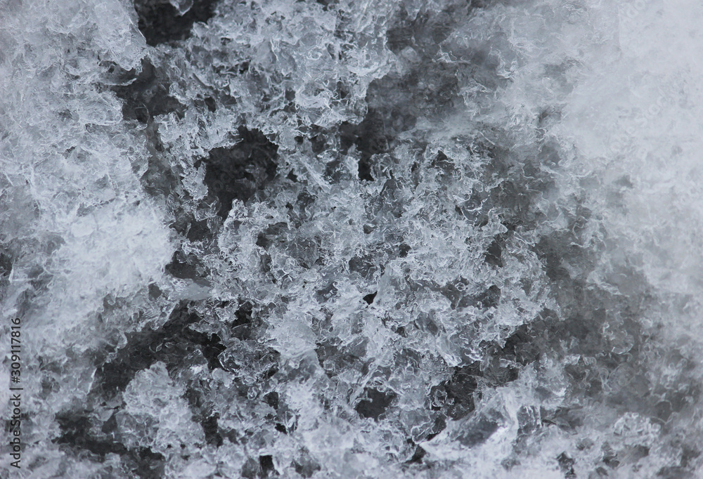 Ice crystals on a dark background. Texture of ice on the river. Frozen water