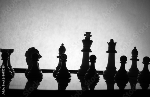 Silhouette shot of chess pieces against the background. Symbolic and cinematic