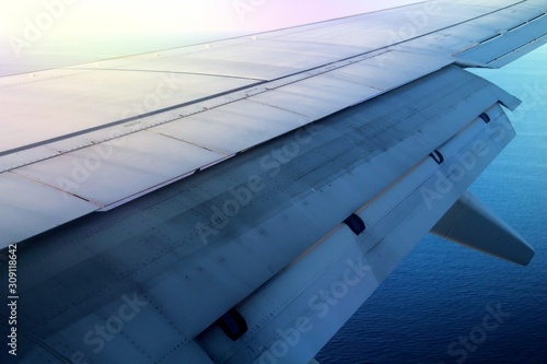 detail of the wing of an airplane with flaps moving during the flight phase just before landing