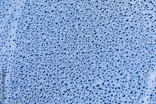 Blue surface with drops of rain water
