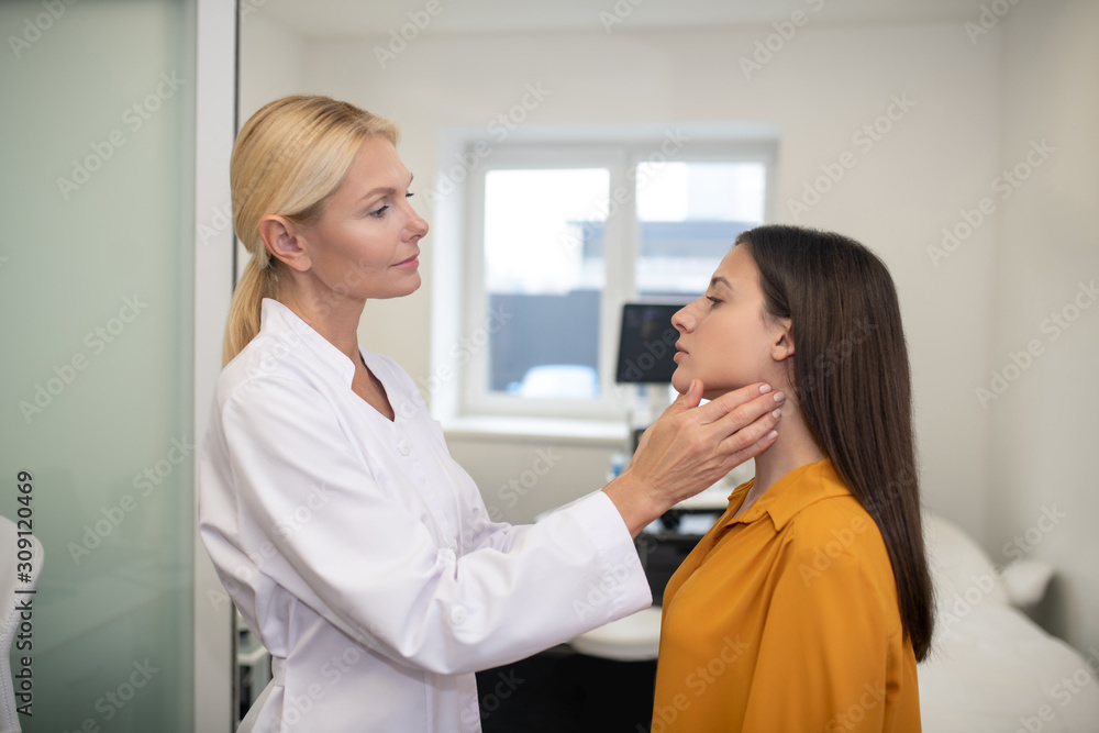 Obraz premium Blond female doctor examining young woman in her office