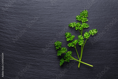 top down of parsley on black slate with copy space