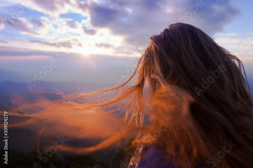 woman's hair in nature with sunset landscape