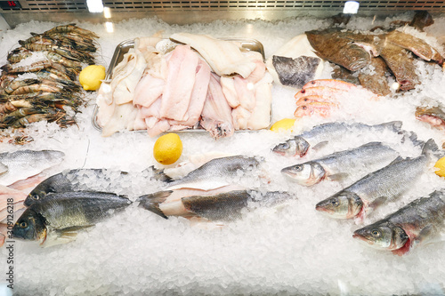 seafood on display in ice, crayfish, various fish, lemon