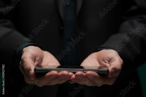 Man holds a smartphone and typing a message