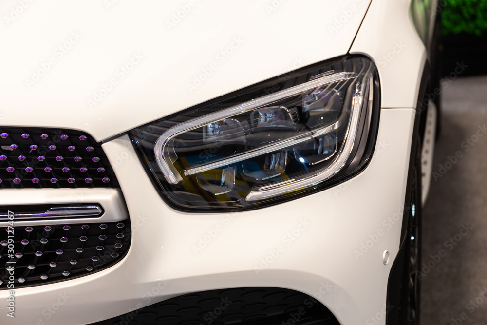 Close up of detail on one of the LED headlights modern and luxury white car. Select focus.