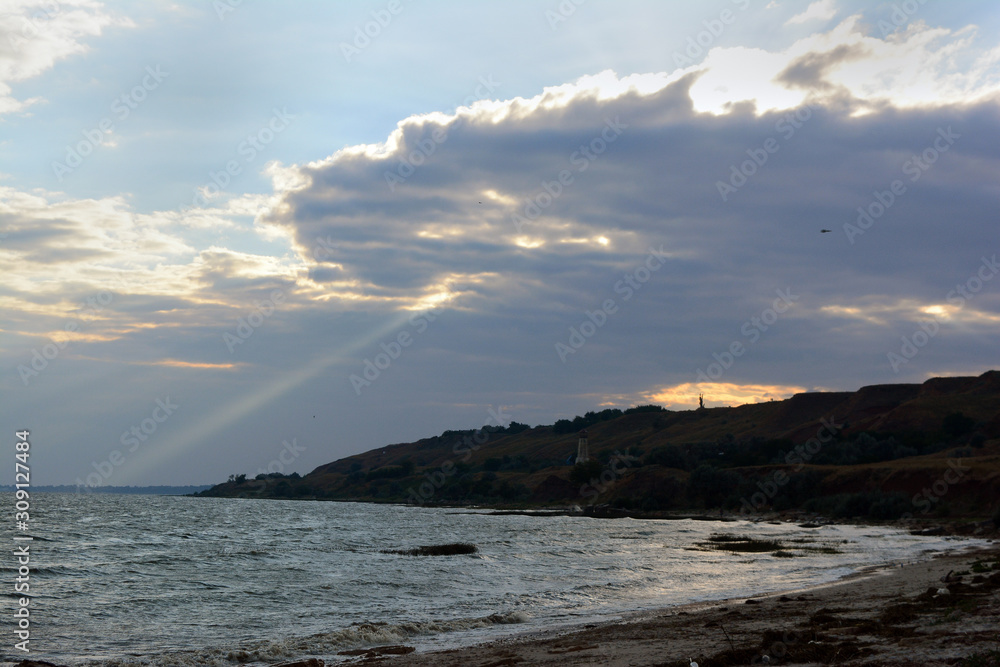 ray of light through clouds at sunset on the coast