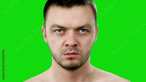 Young handsome man says no and nods his head on green background. Chroma key. Man showing refusal gesture no, shaking his head. It is not for me, leave me in piece, it is unacceptable.