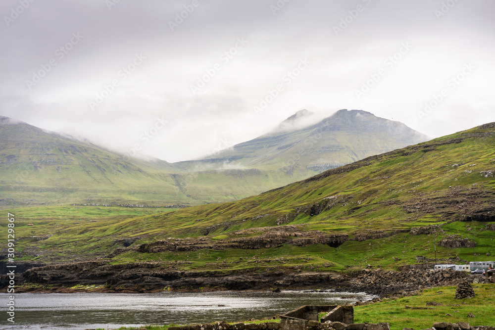Morning clouds on green mountains of Faroe Islands.