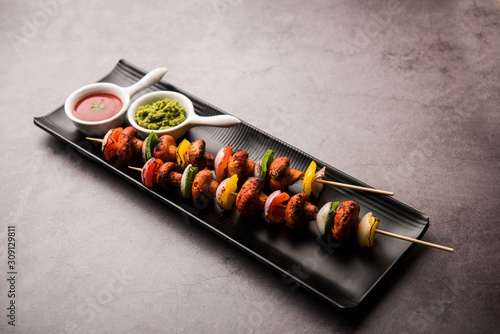 Fotografie Barbecue or tandoori Mushroom Tikka, served in a plate with green chutney and ketchup