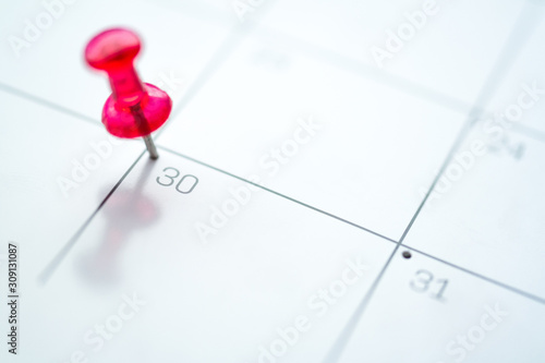 Red push pin on calendar 30th day of the month
