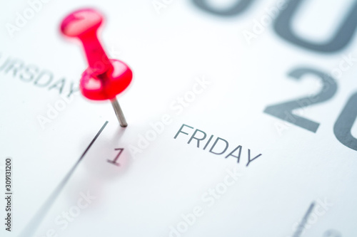 Red push pin on calendar 1st day of the month
