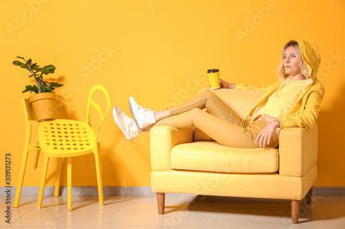 Fashionable young woman relaxing in armchair