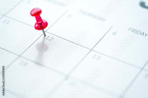 Red push pin on calendar 12th day of the month