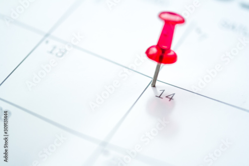Red push pin on calendar 14th day of the month