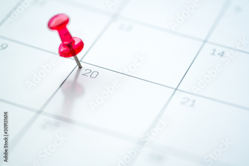Red push pin on calendar 20th day of the month