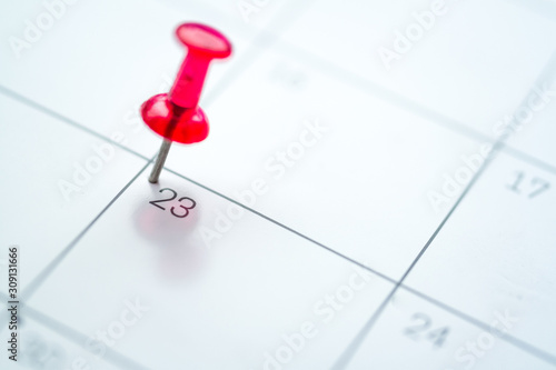 Red push pin on calendar 23rd day of the month photo