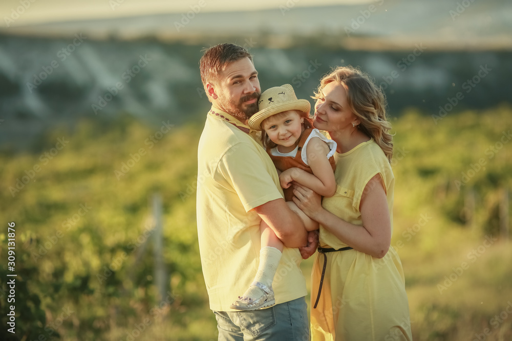 Happy loving family. Husband wife and child at sunset in a grape field. Happy loving family. Husband wife and child at sunset in a grape field.