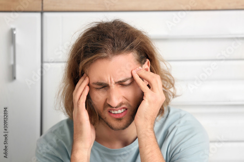 Depressed man in kitchen at...