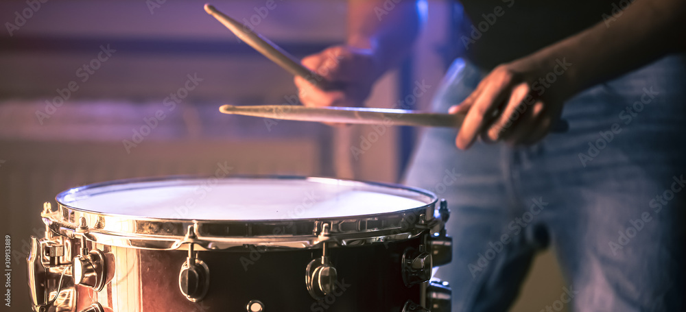 Obraz premium man playing the snare drum on a beautiful colored background