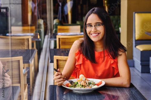 Latinamerican girl have a lunch in restaurant