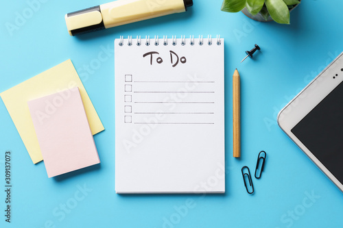 Obraz na płótnie A notebook with to-do list on a blue desk with stationery.