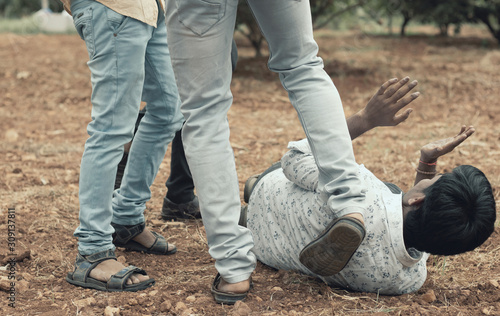 Φωτογραφία Concept of mob lynching - Group of people bullying, kicking a man - Close up of