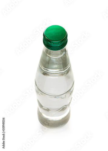 Szklana butelka pełna wody na białym tle