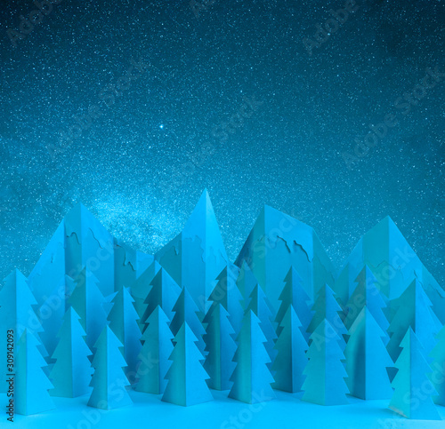 Winter paper landscape with mountains and pine trees at night
