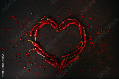 Hot dry red pepper over black background. Chilli pepper heart