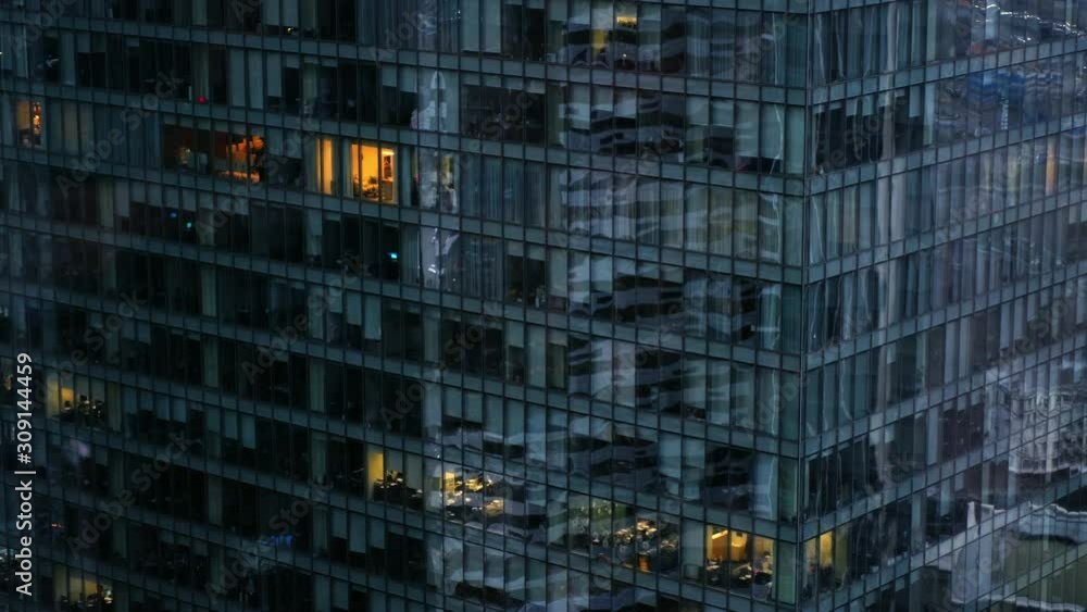 panorama camera on a glass office building in the evening. gray twilight but in windows still continues office work. late evening in the city panorama camera on a glass office building in the evening. gray twilight but in windows still continues office work. late evening in the city