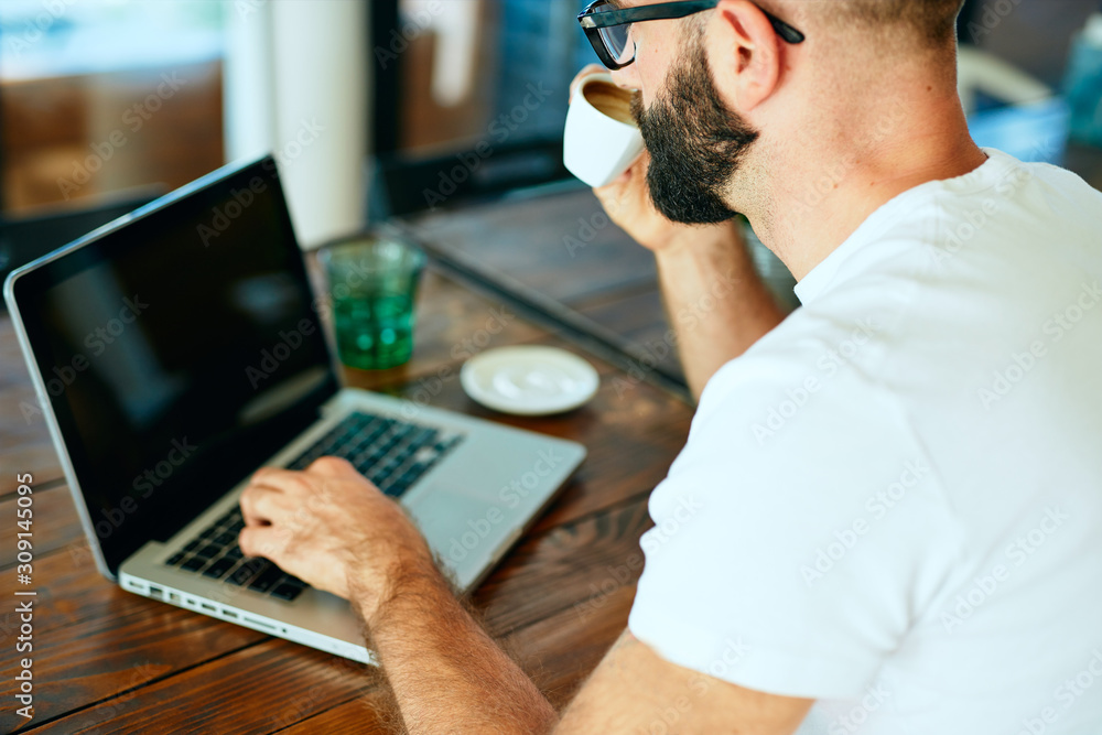 © Tijana - Attractive bearded man with glasses sitting in a cafe enjoying coffee © Tijana - Attractive bearded man with glasses sitting in a cafe enjoying coffee
