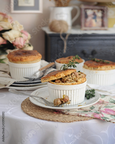portioned cakes with filling in provence style on a light wooden vintage table on a background of retro dishes 