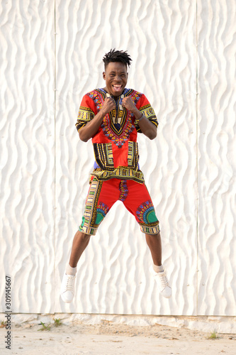 African American guy in national clothes on a background of a white wall